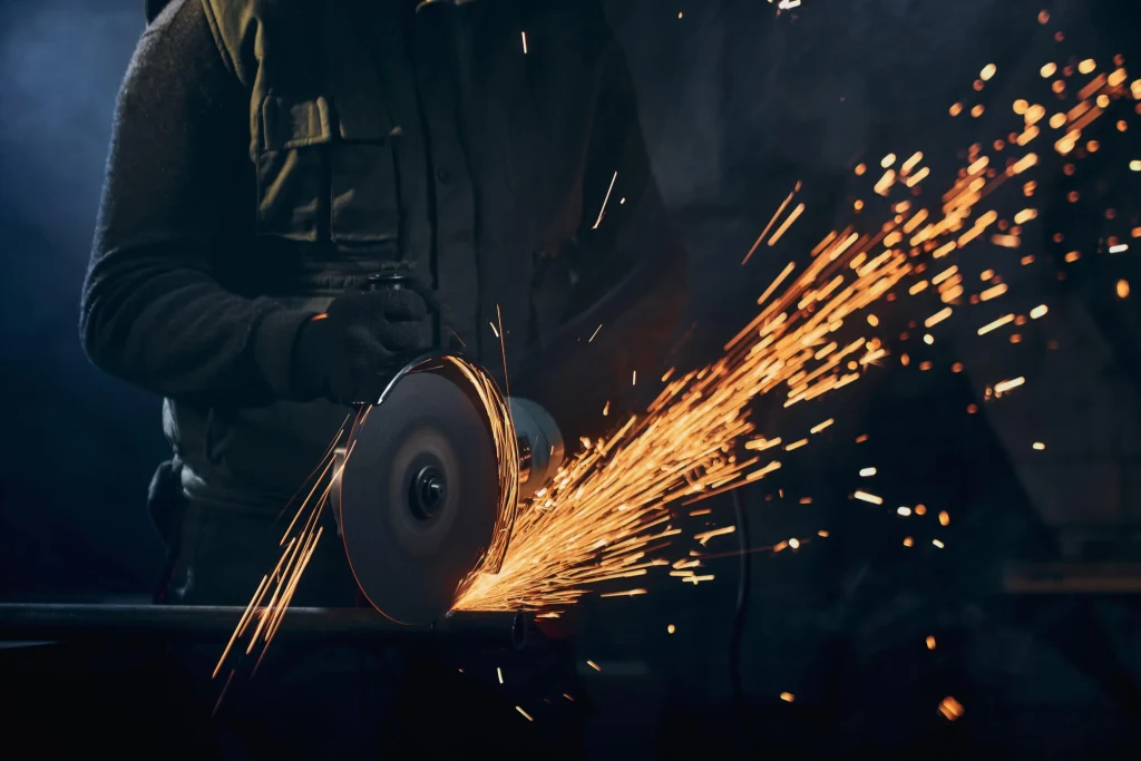 worker-protective-gloves-polishing-metal-with-sparks